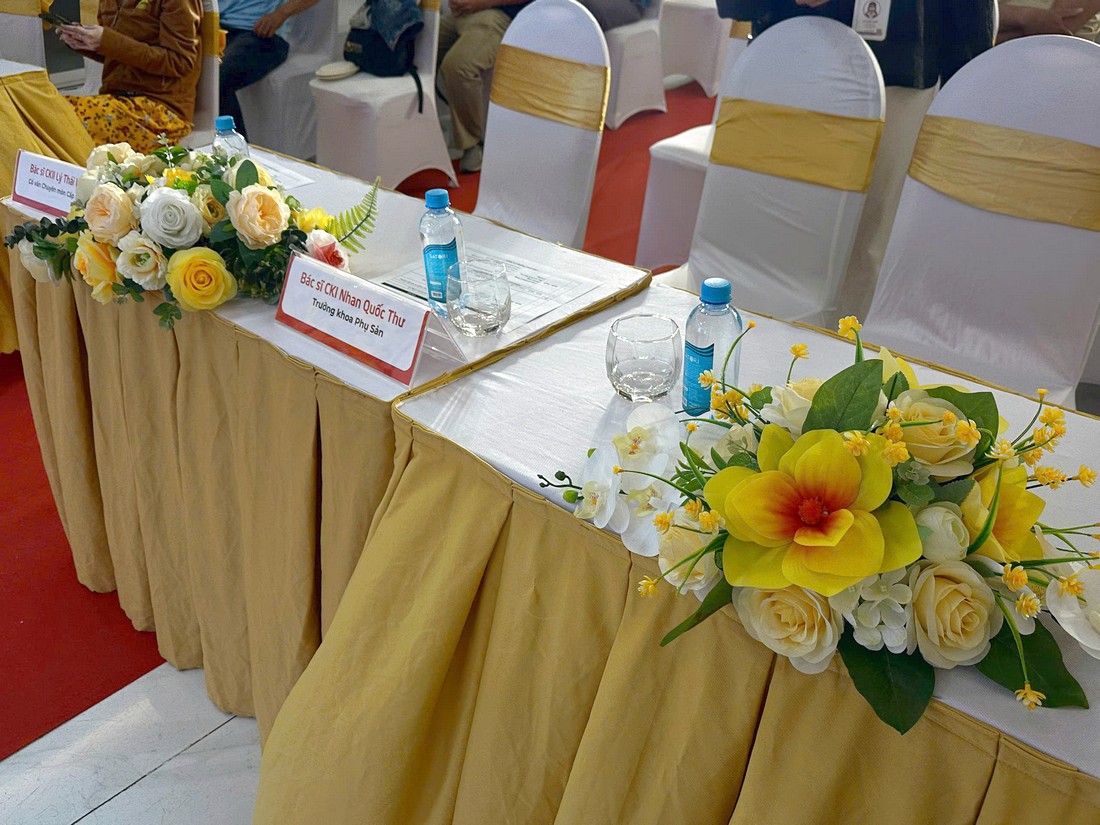 Bàn đại biểu phủ khăn và trang trí hoa tại tọa đàm y khoa