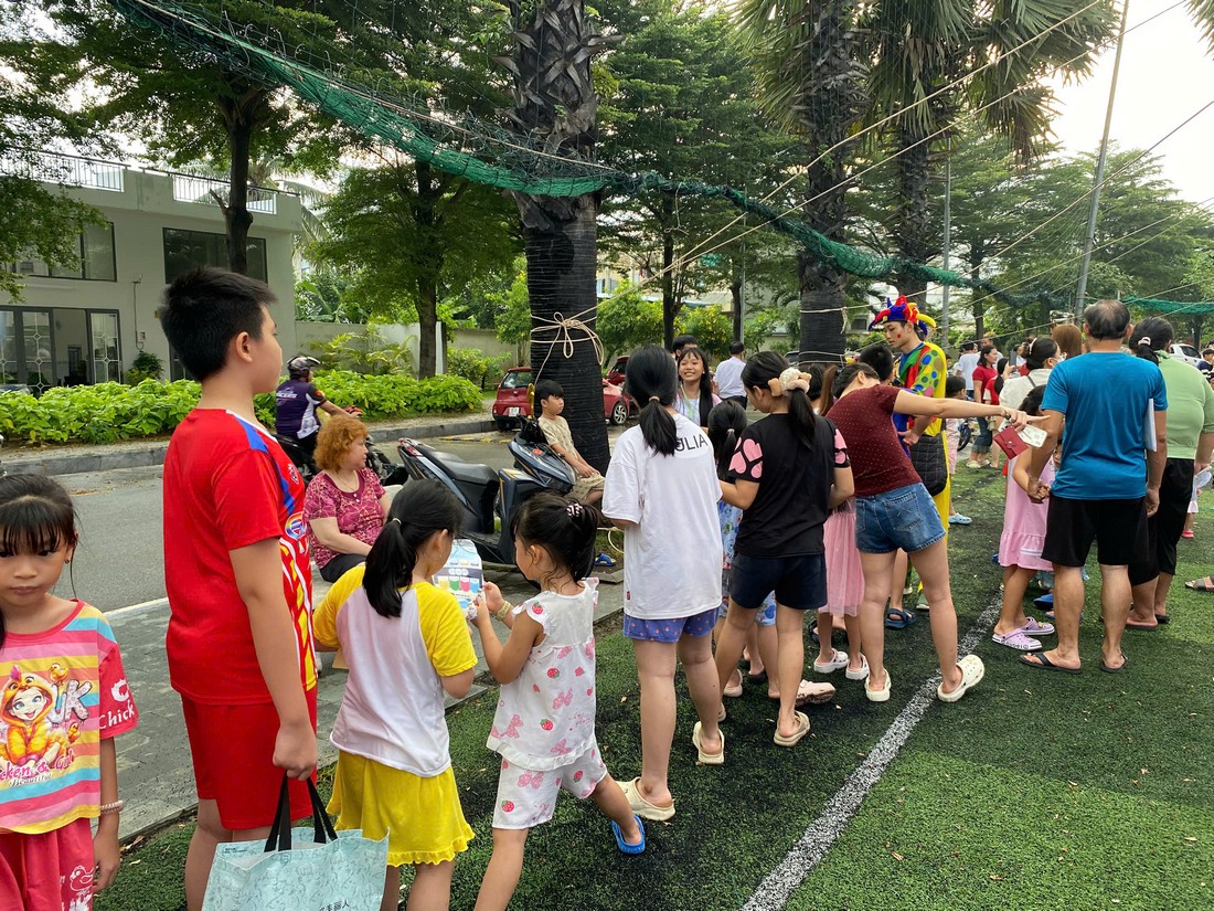 Các em thiếu nhi xếp hàng chờ tham gia trò chơi dưới sự hướng dẫn của nhân sự