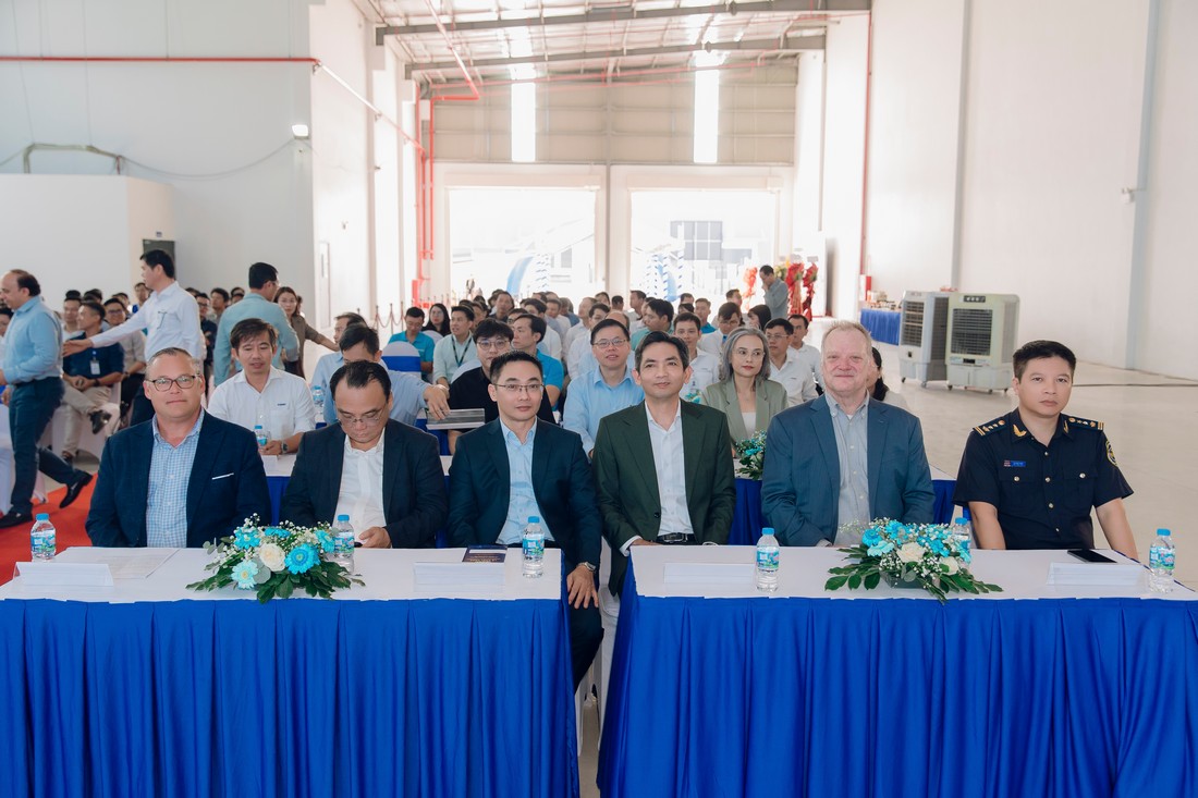 Bàn đại biểu được setup trang trọng với khăn phủ xanh dương, hoa để bàn và nước suối phục vụ khách mời