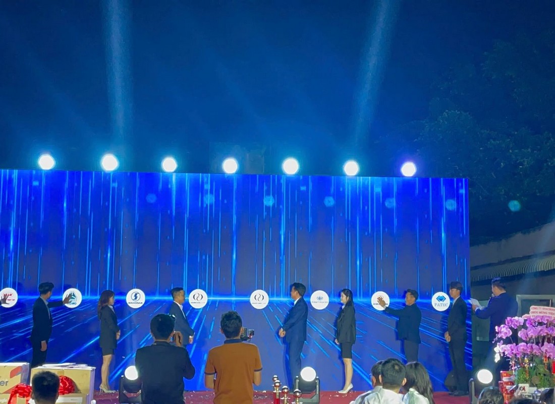 Các đại diện tham gia hoạt động trên sân khấu trước màn hình LED tại Hoàng Long Auto.